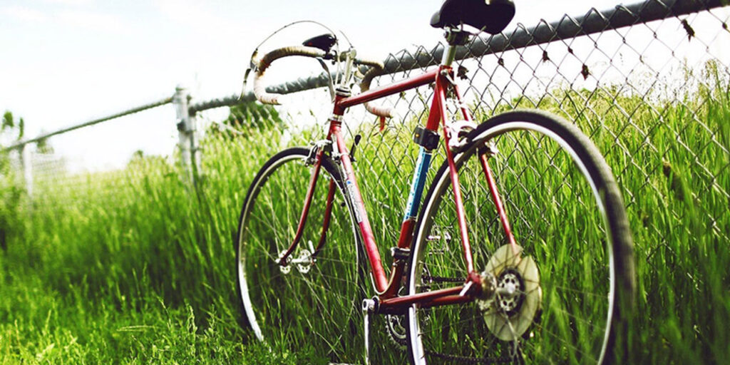 old bike leaning on fence